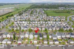 Overhead perspective of a residential neighborhood featuring multiple single-family homes with pitched roofs and individual garages - 