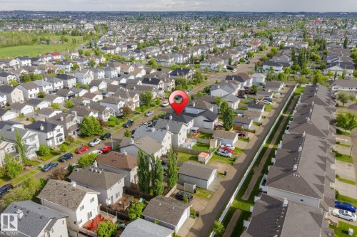 Aerial perspective showcasing a residential neighborhood with detached homes featuring various rooflines and exterior finishes - 220 85St, Edmonton, AB 