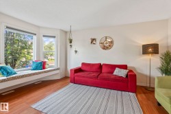 Expansive bay window with a built-in window seat and wood-finish flooring - 