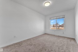Bright room with neutral carpeting and white walls - 