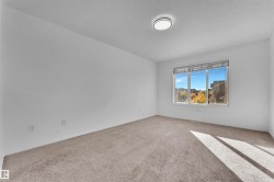 Neutral-toned carpet flooring and white painted walls define this spacious room - 