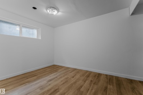 Room featuring wood-finish flooring, white baseboards, and a neutral wall palette - 5405 Crabapple Loop, Edmonton, AB 