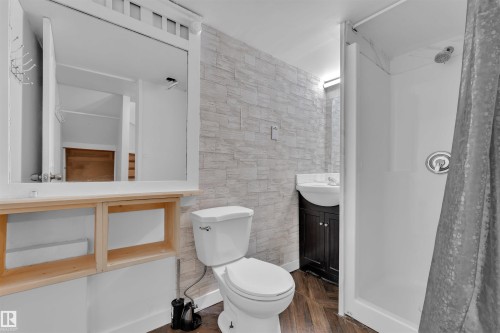 Bathroom featuring a stand-up shower, toilet, and vanity with a wall-mounted sink - 5405 Crabapple Loop, Edmonton, AB 