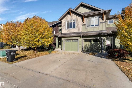 Multi-story residential facade featuring a concrete driveway and attached garages - 5405 Crabapple Loop, Edmonton, AB 