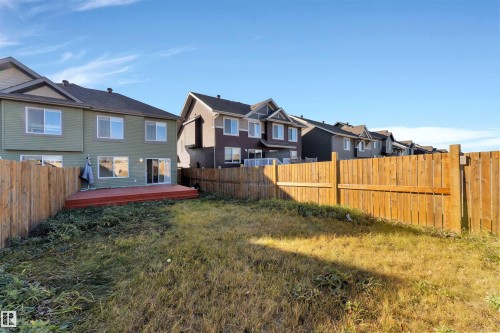 Rear exterior of the property featuring a private wood fence enclosing the backyard - 5405 Crabapple Loop, Edmonton, AB 