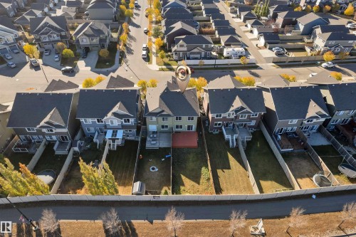 Residential property featuring a rear deck with pergola, private fenced yard, and direct access to a paved walking path - 5405 Crabapple Loop, Edmonton, AB 