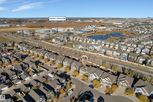 Aerial perspective showcasing the residential neighborhood with a prominent body of water, commercial structures, and extensive road infrastructure - 5405 Crabapple Loop, Edmonton, AB 