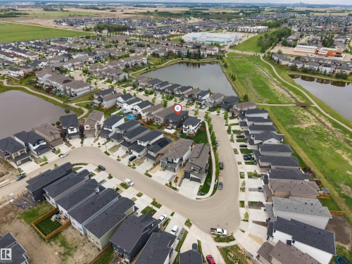 Aerial perspective of a developed residential community featuring multiple homes and two ponds - 6203 47 Avenue, Beaumont, AB 