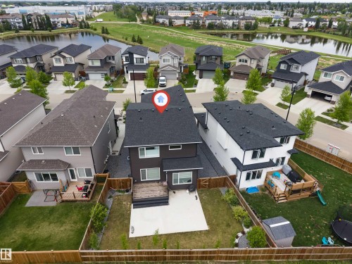Two-story contemporary residence with a dark facade, featuring a rear deck and concrete patio space - 6203 47 Avenue, Beaumont, AB 