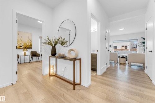 Light wood-finish flooring extending throughout the hallway and into other rooms - 6203 47 Avenue, Beaumont, AB 