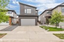 Modern exterior featuring a dark brick facade, gray siding, and an asymmetrical roofline - 6203 47 Avenue, Beaumont, AB 