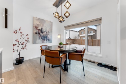 Dining area featuring light wood-finish flooring and a large window - 6203 47 Avenue, Beaumont, AB 