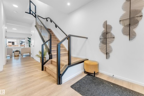 Contemporary staircase featuring glass panels and black metal railings - 6203 47 Avenue, Beaumont, AB 