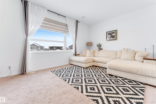 Bright living area featuring a large picture window, recessed lighting, and carpet flooring - 6203 47 Avenue, Beaumont, AB 