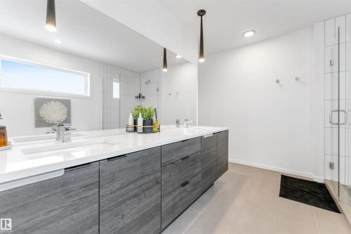 Dual vanity with integrated sinks, quartz countertop, and wood-finish cabinetry - 6203 47 Avenue, Beaumont, AB 
