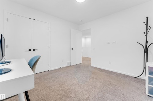 Carpeted room featuring white walls, white baseboards, and a white ceiling with a flush-mount light fixture - 6203 47 Avenue, Beaumont, AB 