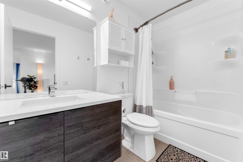 Contemporary bathroom featuring a dark wood-finish vanity with an integrated rectangular sink and chrome faucet - 6203 47 Avenue, Beaumont, AB 
