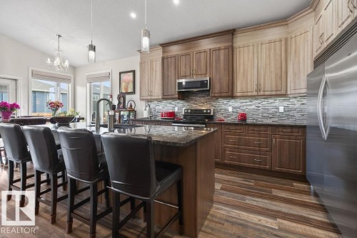 Kitchen featuring two-tone cabinetry, stainless steel appliances, and a textured tile backsplash - 71 Ratelle Circle, St. Albert, AB 