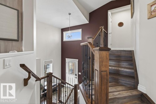 Wood-finish staircase with wrought iron spindles and a natural wood banister - 71 Ratelle Circle, St. Albert, AB 