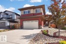 Contemporary two-story residence featuring a two-car garage, red horizontal siding, and a contrasting beige upper facade - 71 Ratelle Circle, St. Albert, AB 