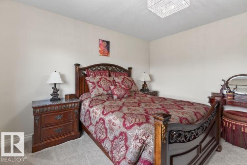 Carpeted room featuring light-colored walls and a crystal-style flush mount ceiling light - 71 Ratelle Circle, St. Albert, AB 