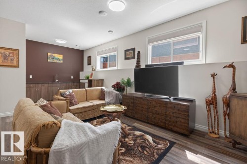 Open-concept living space featuring wood-finish flooring and multiple recessed ceiling lights - 71 Ratelle Circle, St. Albert, AB 