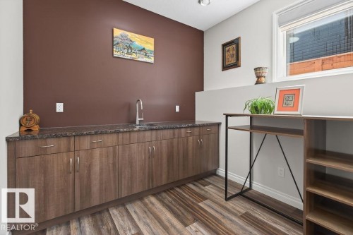 Extensive built-in cabinetry with a dark speckled countertop and undermount sink - 71 Ratelle Circle, St. Albert, AB 