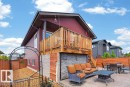 Rear exterior featuring a spacious elevated wood-finish deck with stairs leading to a concrete patio - 71 Ratelle Circle, St. Albert, AB 