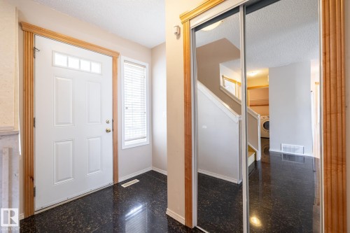 Entryway featuring dark, high-gloss flooring and a white front door with transom lites - 55 Lamplight Cove, Spruce Grove, AB - Indoor Photo Showing Other Room