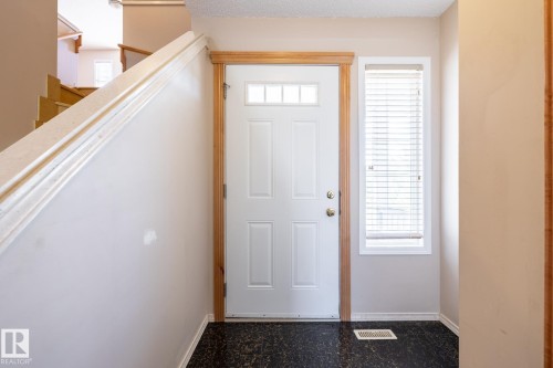 Entryway featuring a paneled white door with clear glass lites and a brass-finish doorknob - 55 Lamplight Cove, Spruce Grove, AB - Indoor Photo Showing Other Room