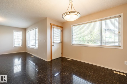 Entryway featuring high-gloss dark flooring, a white paneled door with a privacy blind, and a contemporary semi-flush mount light fixture - 55 Lamplight Cove, Spruce Grove, AB - Indoor Photo Showing Other Room