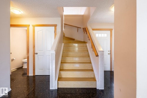 Central staircase with wood-finish handrails and light-toned treads - 55 Lamplight Cove, Spruce Grove, AB - Indoor Photo Showing Other Room