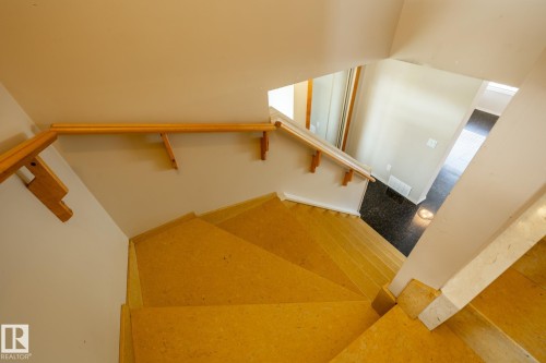 Descending staircase featuring light-toned treads and risers, natural wood handrails, and a contrasting dark-toned flooring at the base - 55 Lamplight Cove, Spruce Grove, AB - Indoor Photo Showing Other Room