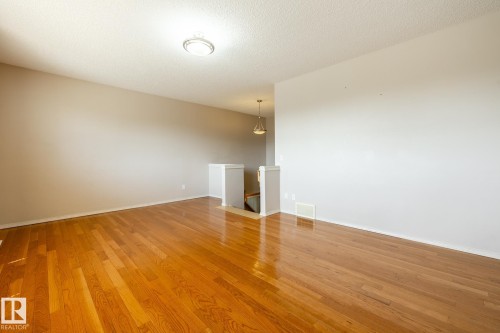 Spacious interior featuring wood-finish flooring, neutral wall tones, and recessed lighting - 55 Lamplight Cove, Spruce Grove, AB - Indoor Photo Showing Other Room