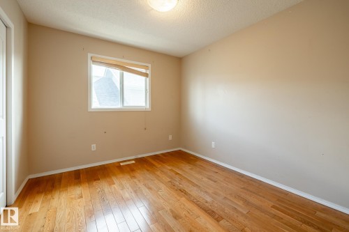 Hardwood flooring and light-toned walls create a neutral palette - 55 Lamplight Cove, Spruce Grove, AB - Indoor Photo Showing Other Room
