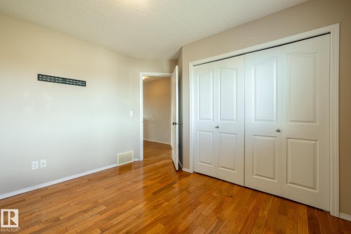 Room featuring wood-finish flooring, neutral wall paint, and white trim - 55 Lamplight Cove, Spruce Grove, AB - Indoor Photo Showing Other Room