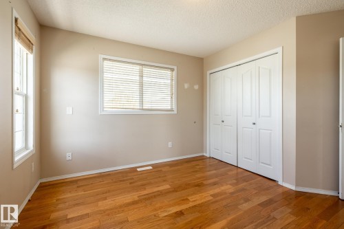 Spacious room featuring wood-finish flooring, neutral-toned walls, and white trim - 55 Lamplight Cove, Spruce Grove, AB - Indoor Photo Showing Other Room