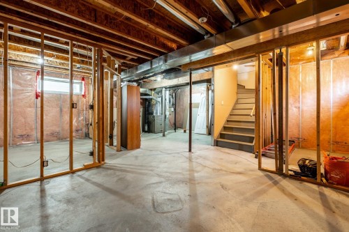 Unfinished basement space featuring exposed wood framing, concrete flooring, visible HVAC ductwork, and an open stairwell - 55 Lamplight Cove, Spruce Grove, AB - Indoor Photo Showing Basement