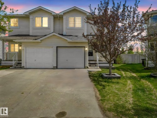 Two-story residence featuring light-colored siding and a multi-car driveway - 2921 23 Street, Edmonton, AB 