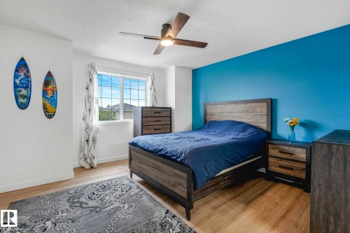 Bright interior space featuring wood-finish flooring and a ceiling fan with integrated lighting - 2921 23 Street, Edmonton, AB 