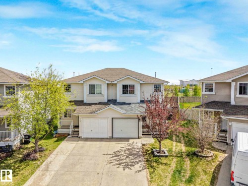 Two-story residential building featuring light-colored siding and a multi-pitch roof - 2921 23 Street, Edmonton, AB 