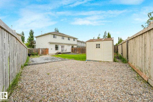 Gravel yard with a detached storage shed, bordered by a wooden privacy fence - 2921 23 Street, Edmonton, AB 