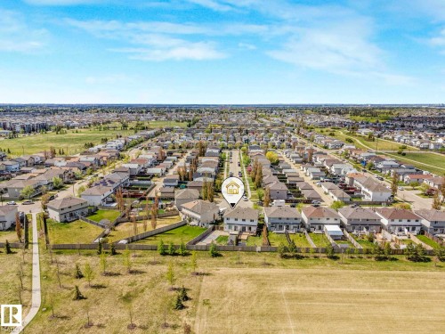 Aerial perspective showcasing a residential development with rows of homes, green spaces, and a paved path - 2921 23 Street, Edmonton, AB 