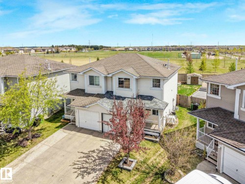 Two-story residence featuring light-colored siding, an attached two-car garage, and a covered front porch - 2921 23 Street, Edmonton, AB 