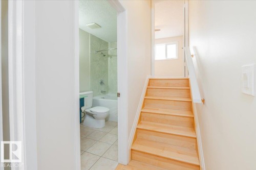 Hardwood staircase with white handrail leading to an upper level - 4107 147 Street, Edmonton, AB 