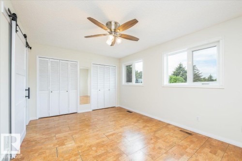 Bright interior space featuring wood-finish flooring and two windows - 4107 147 Street, Edmonton, AB 