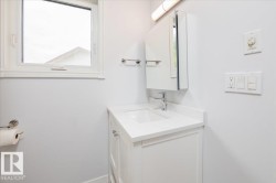Compact bathroom featuring a white vanity with integrated sink, chrome faucet, and coordinating medicine cabinet - 
