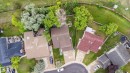 Aerial perspective showcasing a residential property with a brown shingle roof, a concrete driveway, and a spacious green lawn - 4107 147 Street, Edmonton, AB 