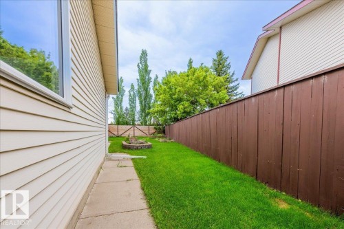 Manicured lawn with a concrete pathway and a wood privacy fence - 4107 147 Street, Edmonton, AB 