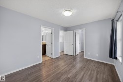 Spacious room featuring wood-finish flooring and light gray walls - 